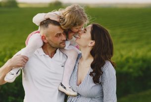 A delightful family moment captured in a lush scenic field, portraying love and happiness.